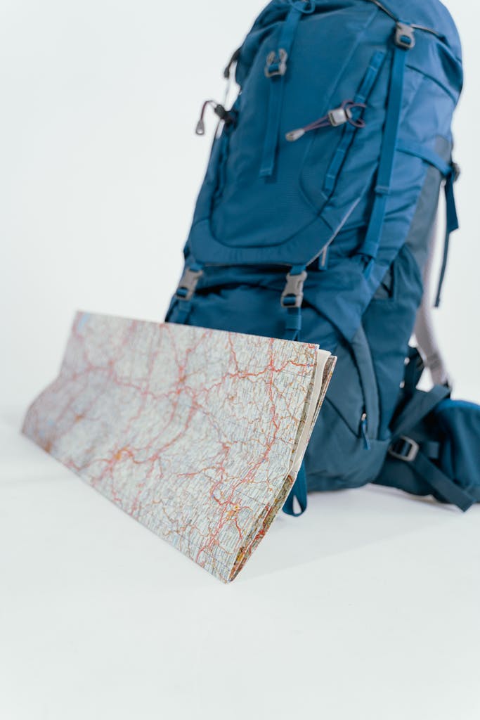 A blue backpack and map set up for hiking and travel adventures, emphasizing the spirit of exploration.